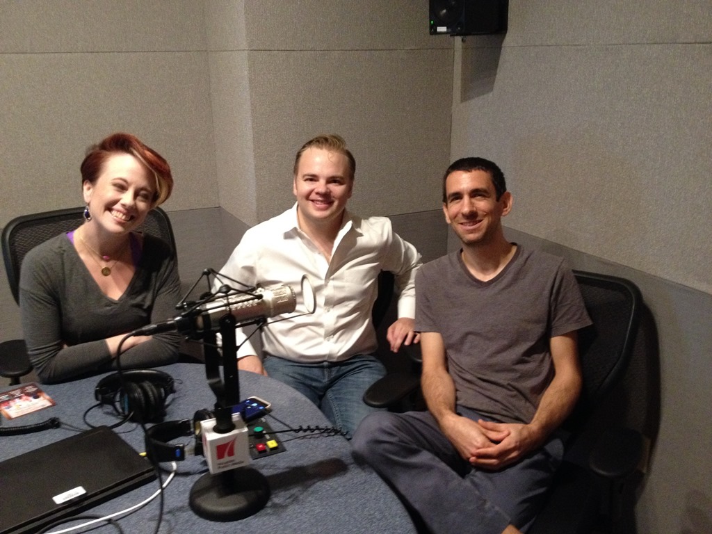 Three musicians pose for a photo in a radio studio