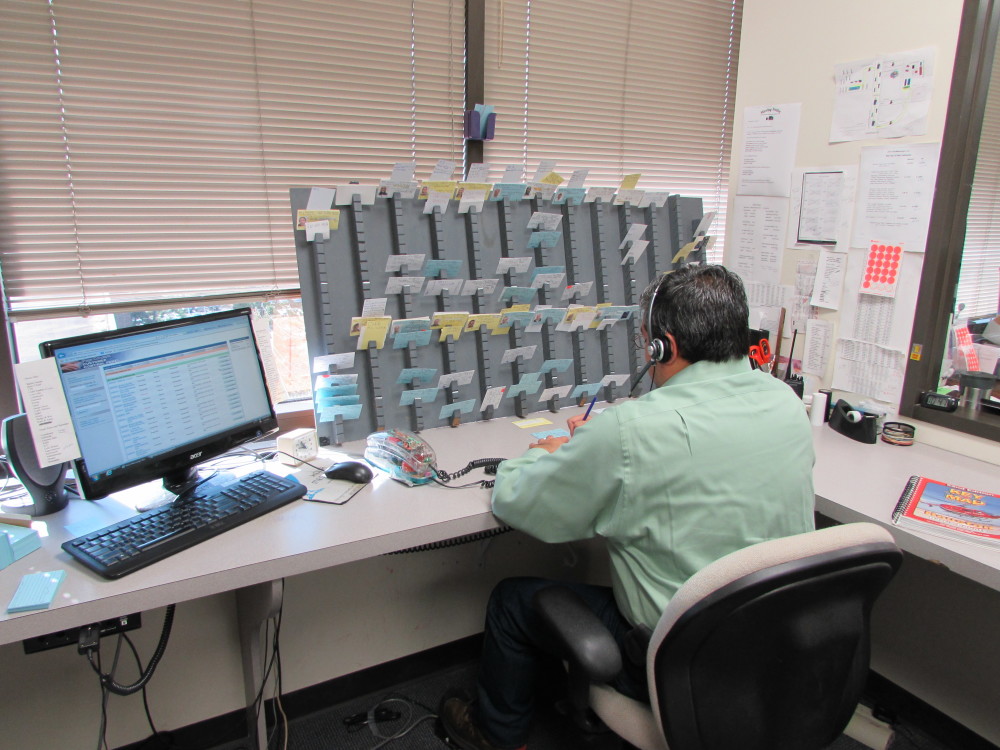 A dispatcher at Hour Messenger in Houston's Energy Corridor uses both a computer and index cards to keep track of deliveries. 