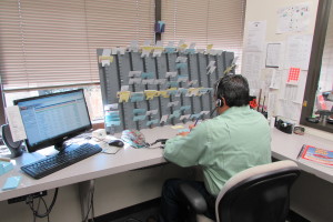 A dispatcher at Hour Messenger in Houston's Energy Corridor uses both a computer and index cards to keep track of deliveries.