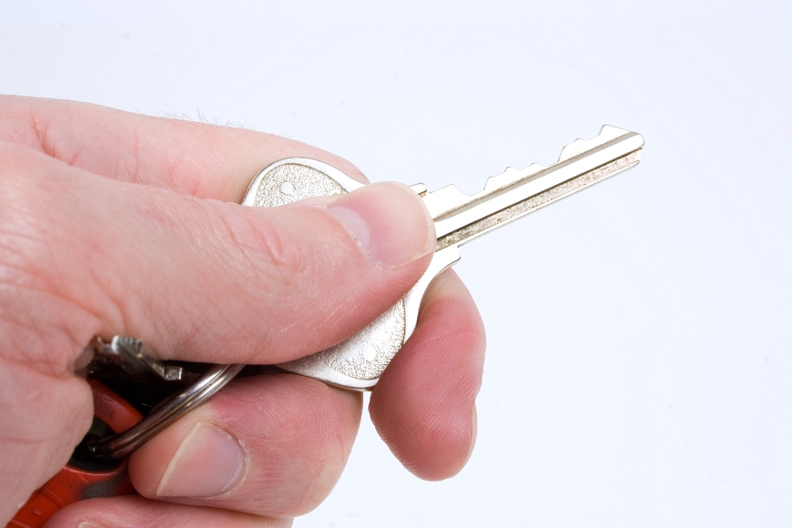 a hand holds a single key