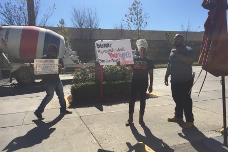 Activists hold signs in protest outside the NAACP award ceremony where Devon Anderson was honored.