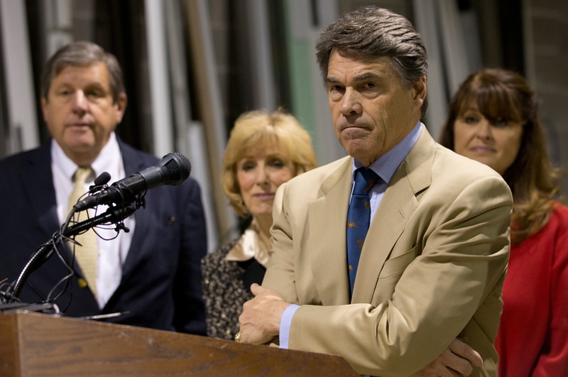 Texas Gov. Rick Perry stands with his arms crossed