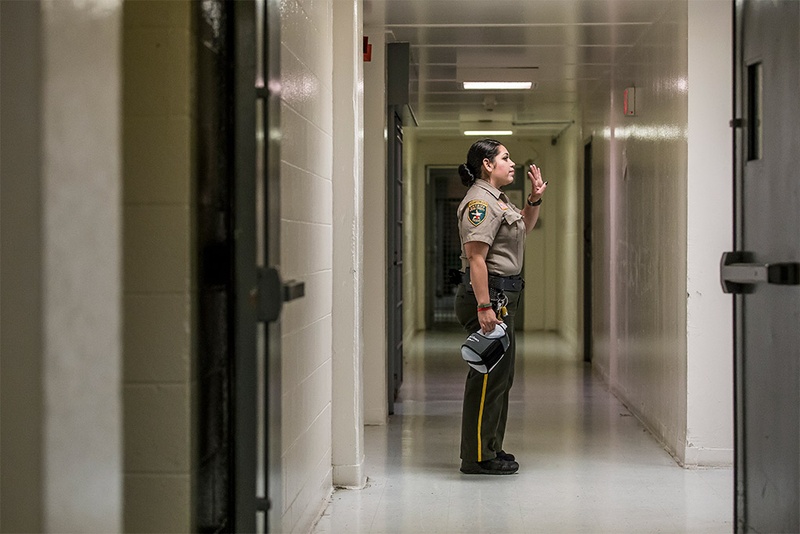 A guard inside the Webb County Jail waves goodbye
