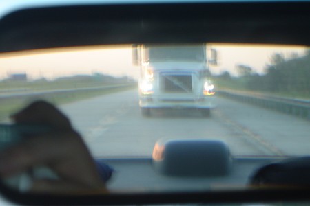 Blurred Transport Truck in Rearview Mirror as seen from Driver Perspective