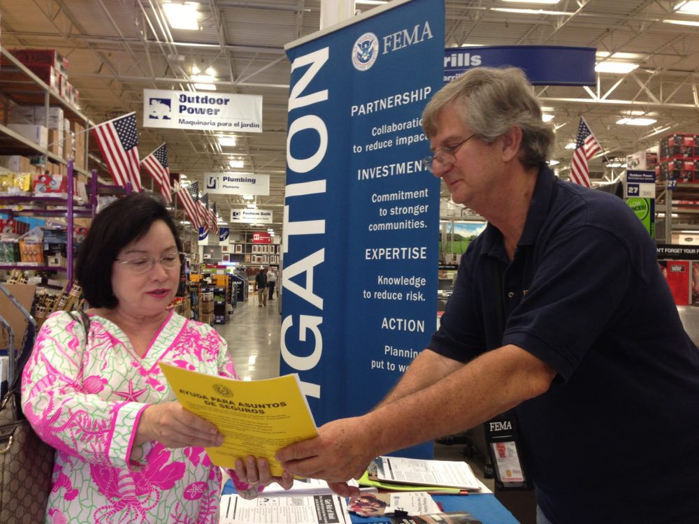 FEMA disaster mitigation specialist Kenneth Milausnic shows Sugarland resident Margie Phillips a brochure about how to reduce the effects of flooding in homes.