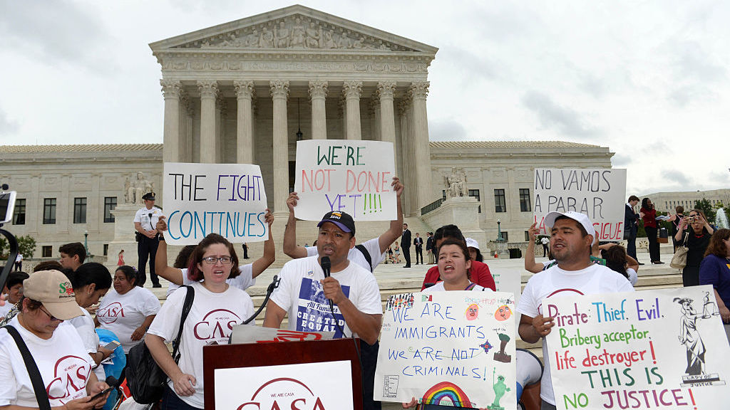 People attend an immigration rally outside the Supreme Court in June. 