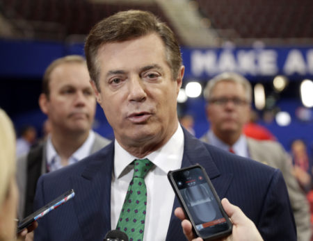 In this July 17, 2016 file photo, Trump Campaign Chairman Paul Manafort talks to reporters on the floor of the Republican National Convention at Quicken Loans Arena in Cleveland as Rick Gates listens at back left. Emails obtained by The Associated Press shed new light on the activities of a firm run by Donald Trump’s campaign chairman. They show it directly orchestrated a covert Washington lobbying operation on behalf of Ukraine’s ruling political party, attempting to sway American public opinion in favor of the country’s pro-Russian government. Manafort and his deputy, Rick Gates, never disclosed their work as foreign agents as required under federal law.
