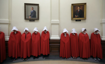 Protesters dressed as characters from "The Handmaid's Tale" chant in the Texas Capitol Rotunda under portraits of former Texas governors George W. Bush and Rick Perry in Austin, Texas, Tuesday, July 18, 2017. State lawmakers begin a special legislative session Republican Gov. Greg Abbott felt compelled to call in order to tackle conservative priorities that stalled previously, chief among them a "bathroom bill" targeting transgender people.