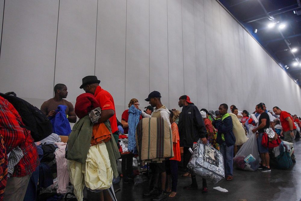 Evacuees seeking shelter from flooding wait in line to get into the George R. Brown Convention Center in Houston on Aug. 27.