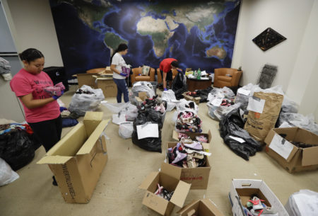Volunteers sort donated items in a makeshift distribution center set up among the cubicles of an office Friday, Sept. 1, 2017, in Pasadena, Texas. Thousands of people have been displaced by torrential rains and catastrophic flooding since Harvey slammed into Southeast Texas last Friday.