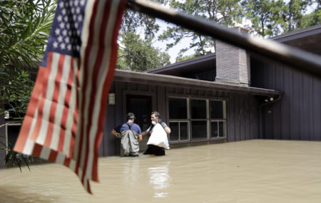 Gaston Kirby, right, and Juan Minutella leave Kirby's flooded home in the aftermath of Hurricane Harvey, Monday, Sept. 4, 2017, near the Addicks and Barker Reservoirs, in Houston.