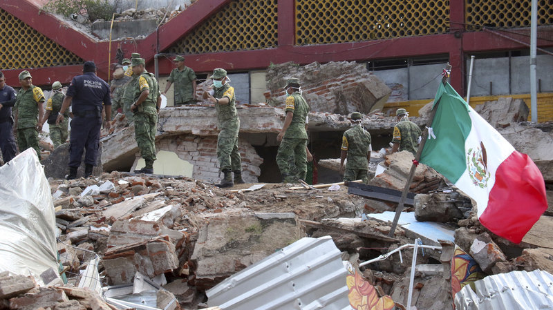 Soldiers remove debris from a partly collapsed municipal building, which was felled by a massive earthquake, in Juchitan, Oaxaca state, Mexico, on Friday.