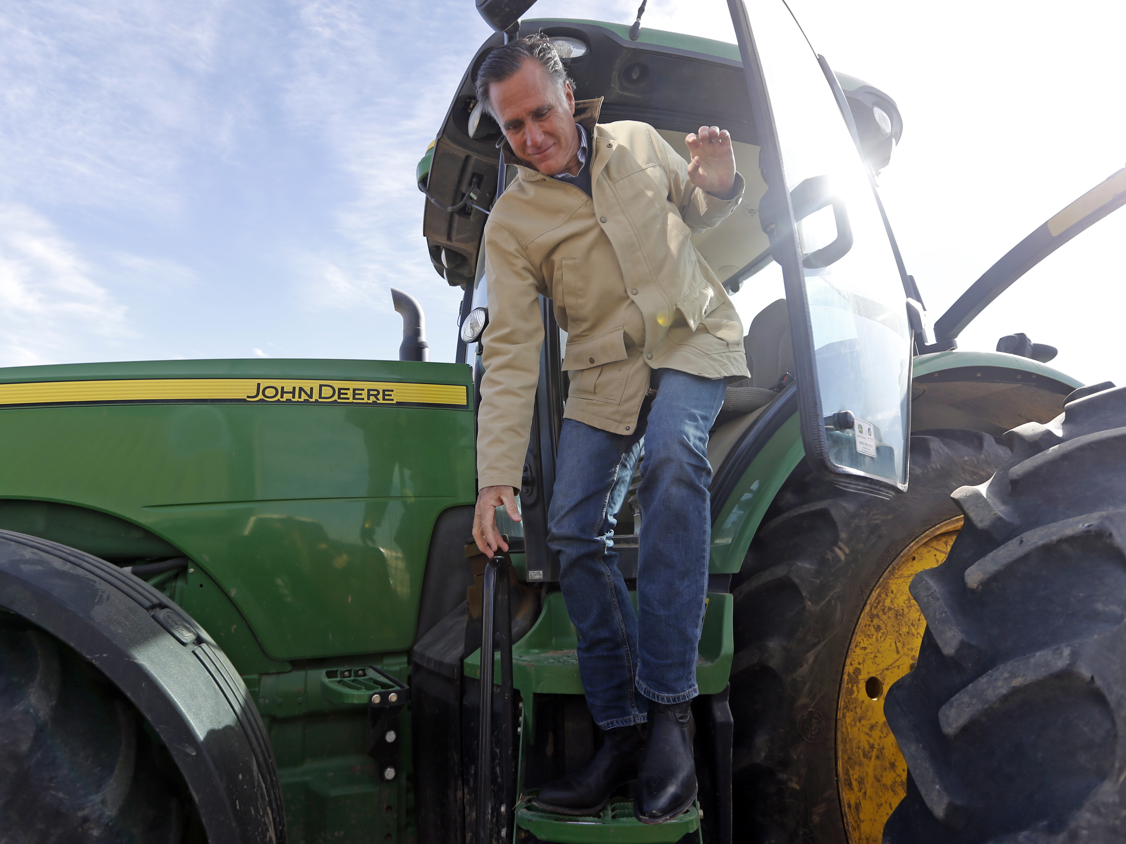 Former Republican presidential candidate Mitt Romney climbs down from a tractor during a tour of Gibson's Green Acres Dairy Friday, Feb. 16, in Ogden, Utah. Romney hopes to win the seat being vacated by retiring seven-term Utah Sen. Orrin Hatch.