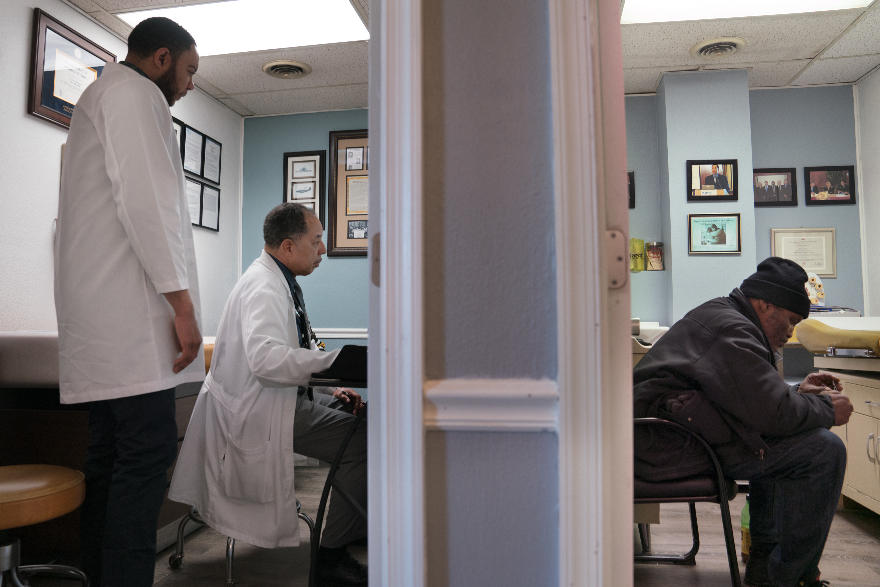 Dr. Scott Whetsell (left) is training with Chapman to better understand how to help the patients that come to the clinic. Gerald A. Goines Sr. (right) waits to see Chapman.
