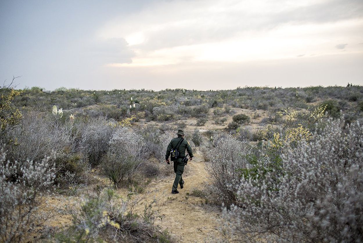 A Border Patrol Agent makes his way through harsh terrain along the Rio Grande River in Starr County, Texas.