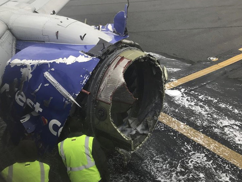 The engine on a Southwest Airlines plane is inspected as it sits on the runway at the Philadelphia International Airport after it made an emergency landing there on Tuesday.