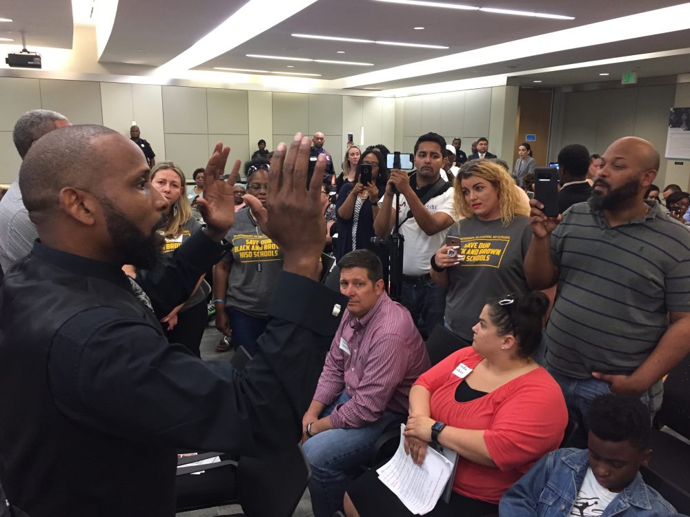 Parent and activist Travis McGee addressed a crowd of people at the HISD meeting while the board was in closed session and before a scuffle erupted with police officers.