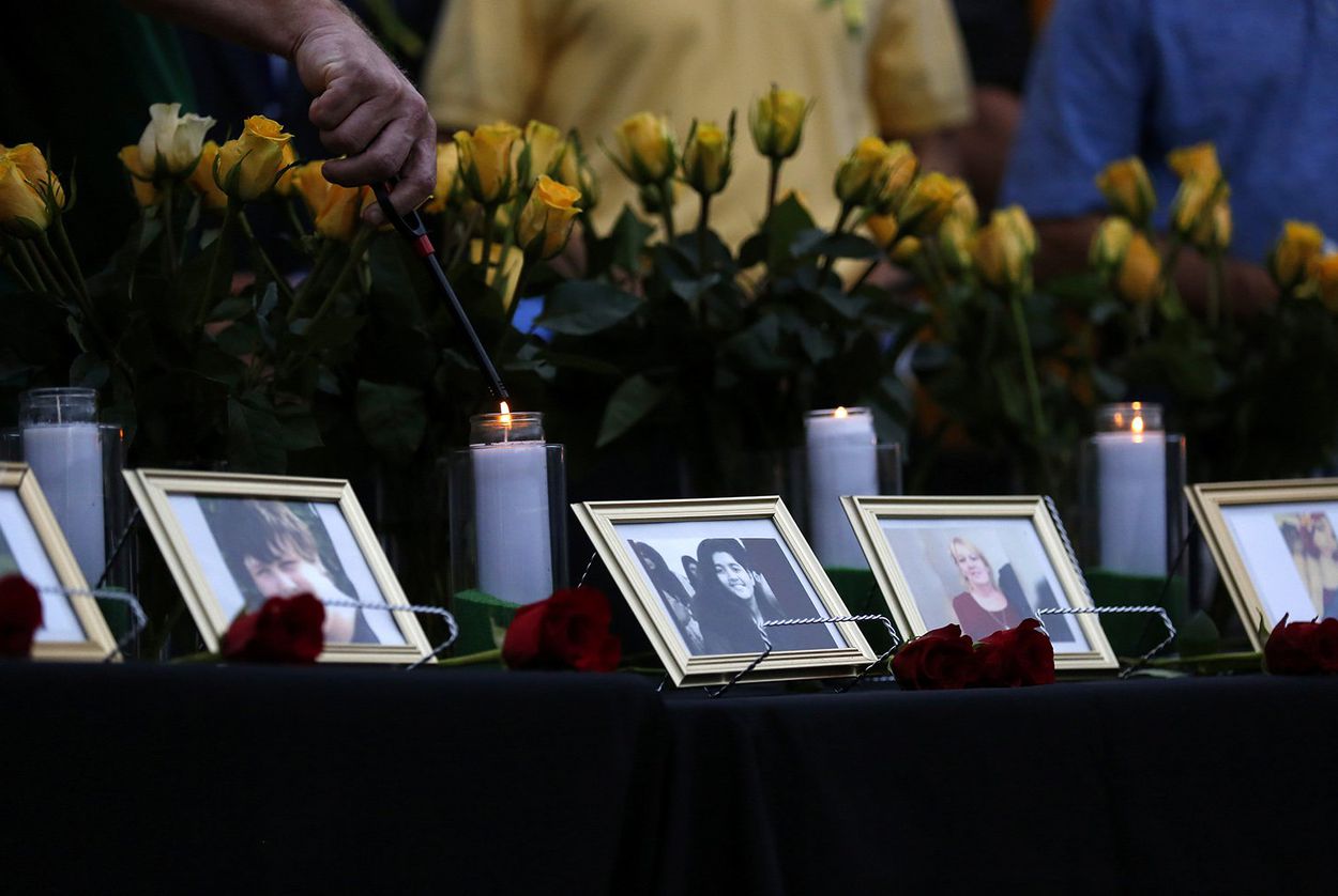 Candles are lit behind images of the victims killed in a shooting at Santa Fe High School during a vigil in League City on May 20, 2018.