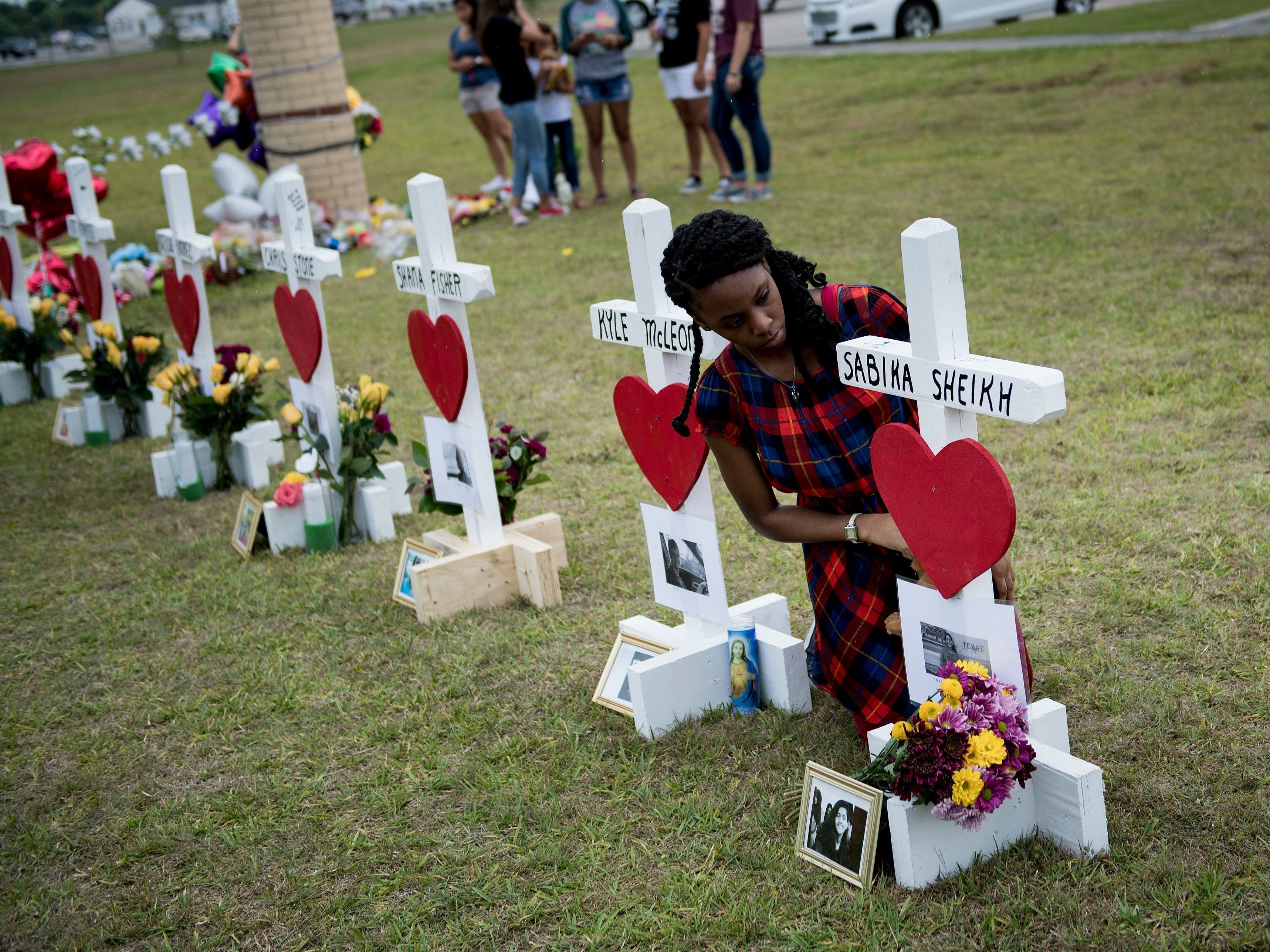 Jai Gillard, a freshman who was in the class where the mass shooting started, looks at a cross for Sabika Sheikh before signing it at a memorial for the victims of the Santa Fe High School shooting on Monday in Santa Fe, Texas.
