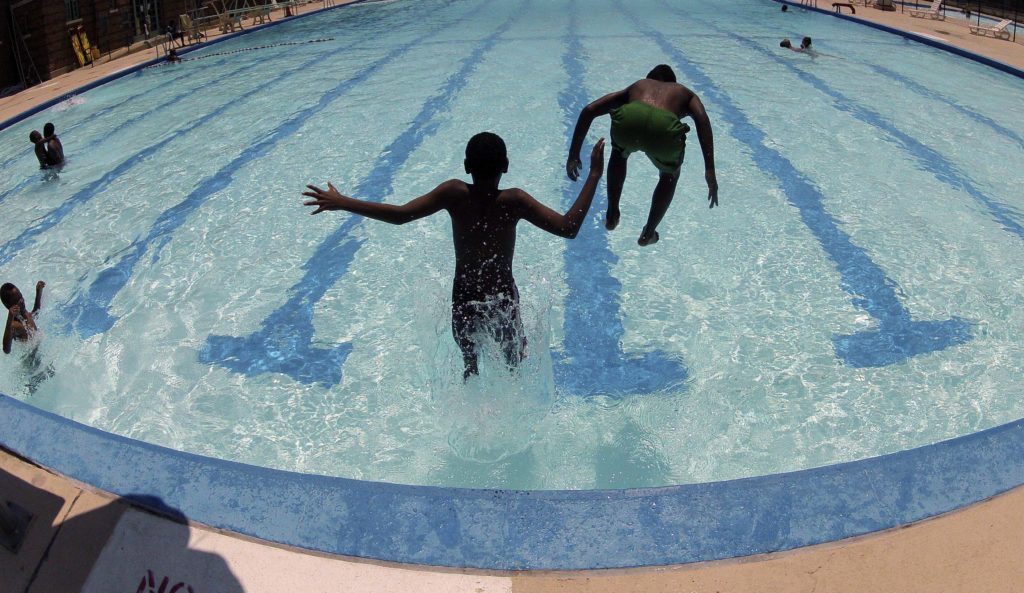 Kids jump into Banneker Pool to try and beat the heat gripping the nation’s capital while in Washington, July 2, 2012. 