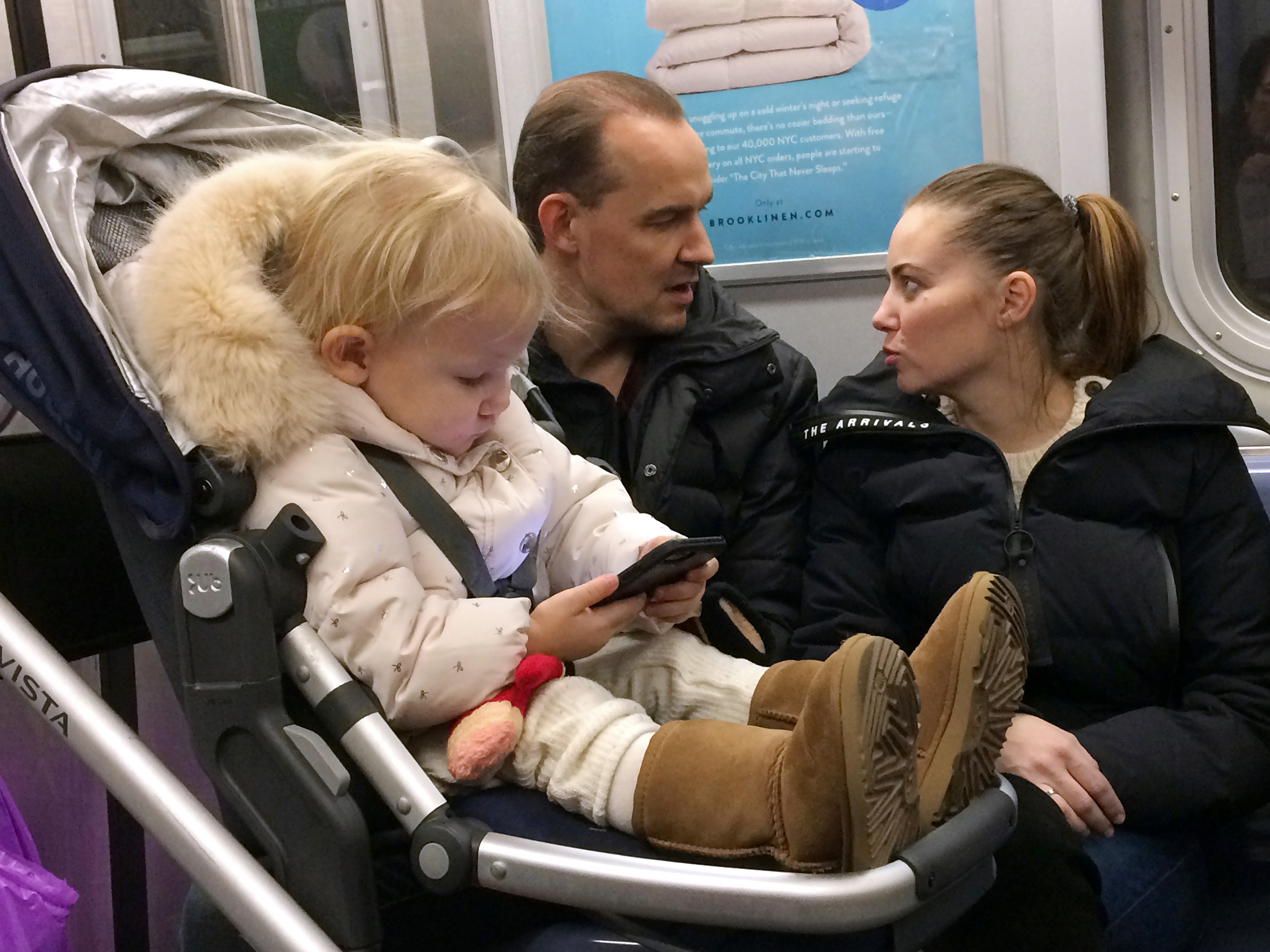A child plays with a mobile phone while riding in a New York subway in December. Two major Apple investors urged the iPhone maker to take action to curb growing smartphone use among children.
