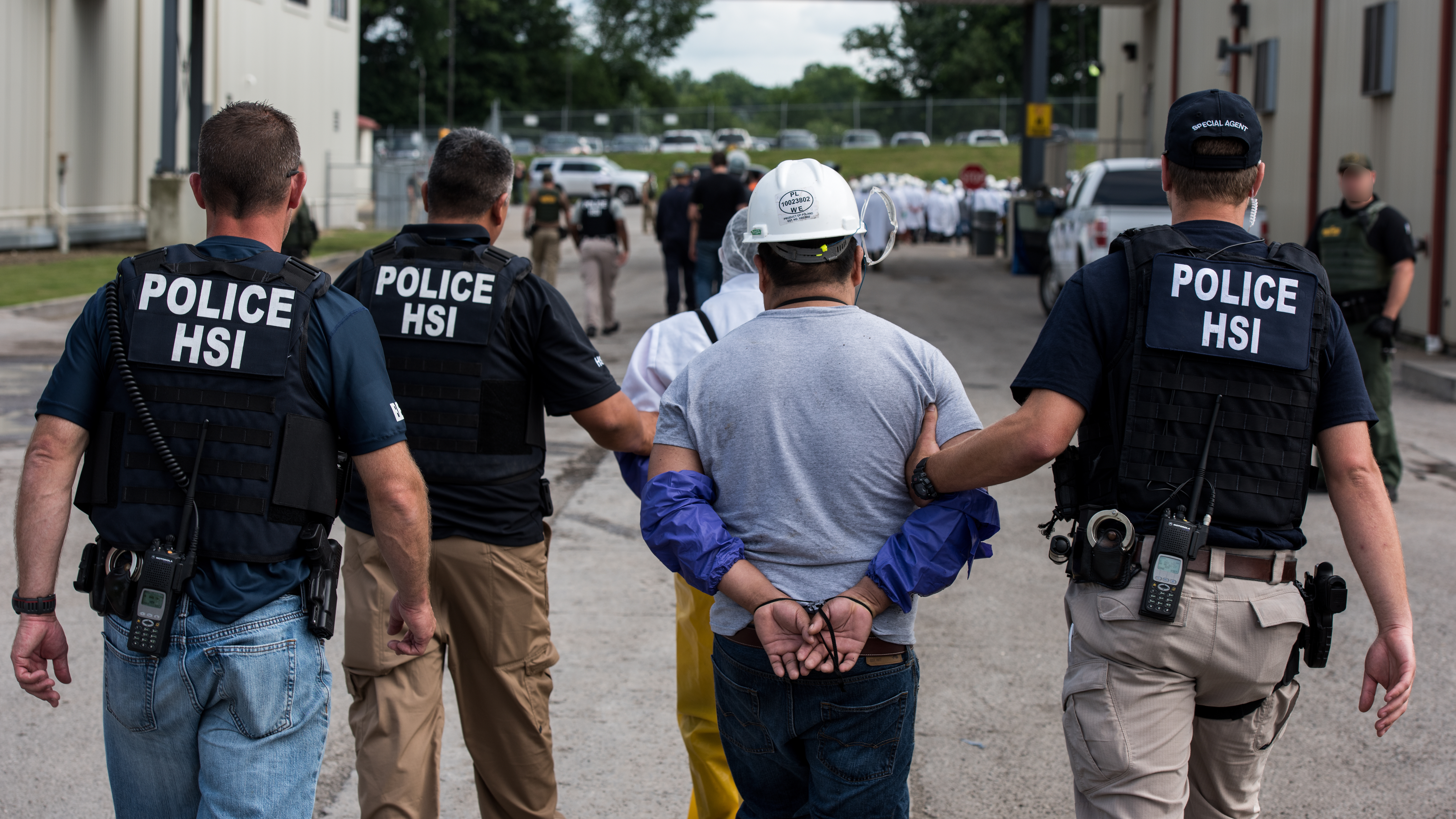 Special agents with Homeland Security Investigations, the investigative arm of U.S. Immigration and Customs Enforcement, lead a man away from Fresh Mark in Salem, Ohio, on Tuesday. The mass arrests were the result of the second such large-scale raid this month.
