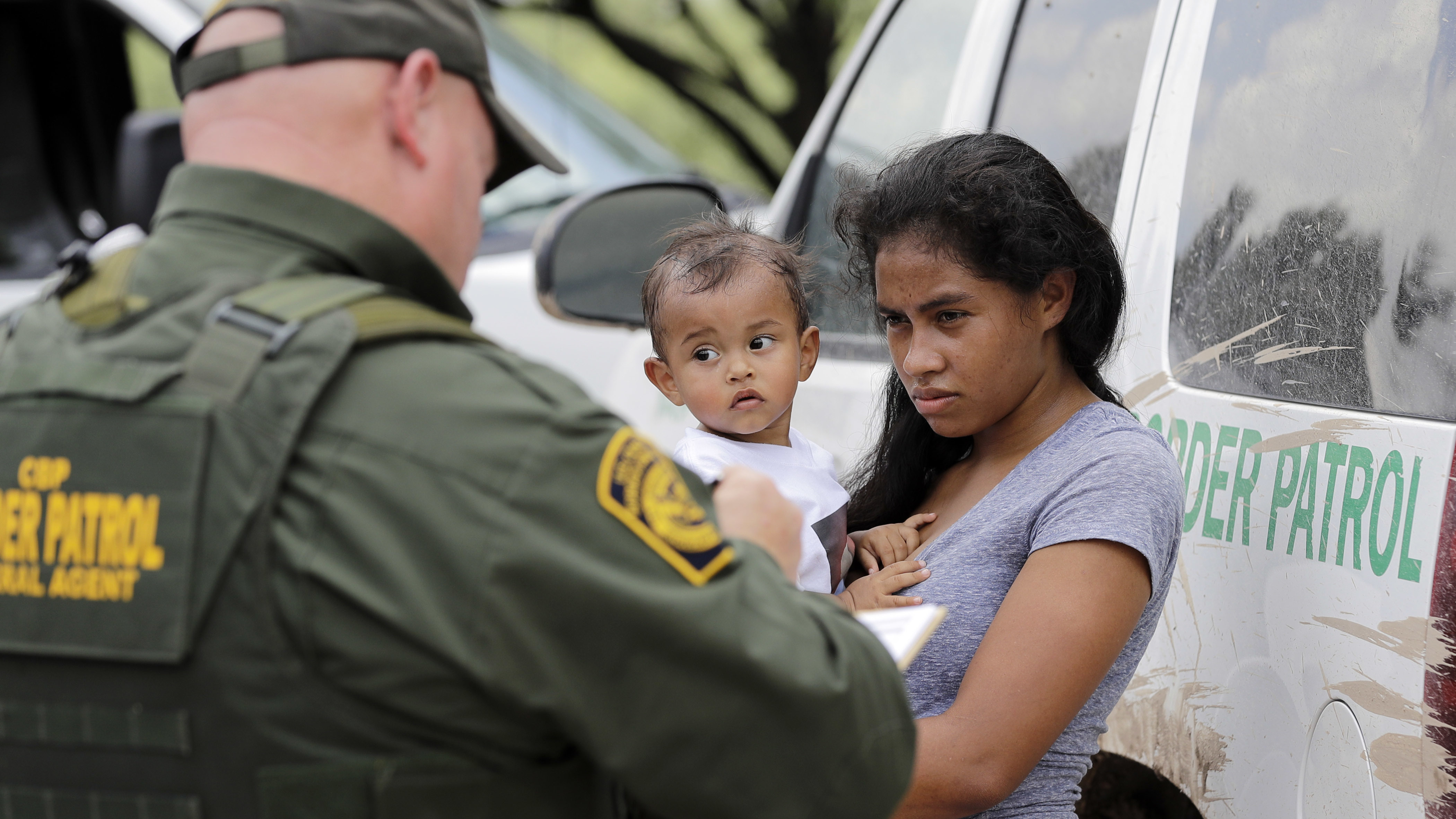 A mother migrating from Honduras holds her 1-year-old child as she surrenders to a U.S. Border Patrol agents after illegally crossing the border, near McAllen, Texas, in late June.
