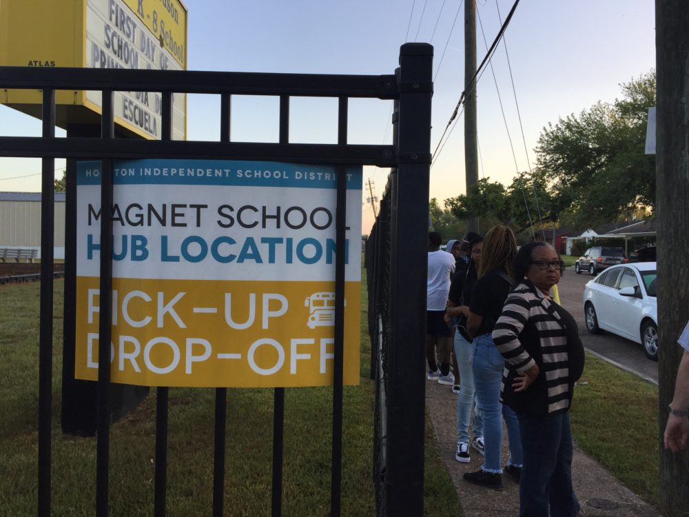 Families wait in line on the first day of school at the magnet bus hub stop at Wilson PK-5 on Monday, Aug. 27, 2018. Problems have plagued the new bus system all week.