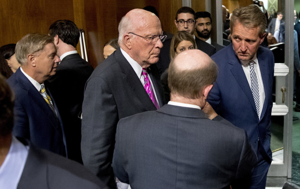 Sen. Jeff Flake, R-Ariz., right, speaks with Patrick Leahy, D-Vt., third from right, and Sen. Chris Coons, D-Del., second from right, at the conclusion of a Senate Judiciary Committee hearing on Capitol Hill in Washington, Friday, Sept. 28, 2018, after Flake calls for an FBI investigation into the allegations brought forward against Supreme Court nominee Judge Brett Kavanaugh. The committee voted along party lines to send the Kavanaugh nomination to the full Senate for a vote. Also pictured is Sen. Lindsey Graham, R-S.C., left. (AP Photo/Andrew Harnik)