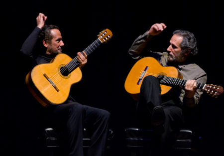 Concert photo of Sergio and Odair Assad performing on guitars