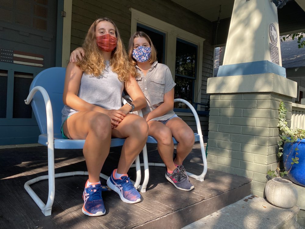 Lily and Piper Jordan wear masks and sit on their front porch. They've spent the last five weeks doing virtual school at home.