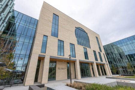 Exterior daylight view of the new college of medicine building, which has a limestone and glass facade