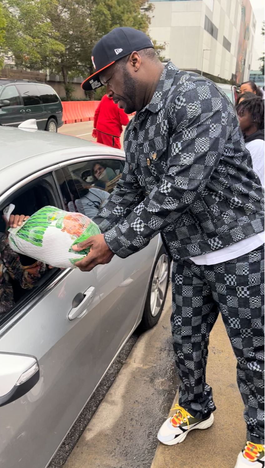Rapper 50 Cent gives out a turkey to a family during a Houston Rockets and G-Unity Foundation giveaway. 
